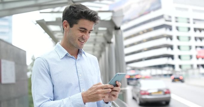 Business man use of mobile phone in city