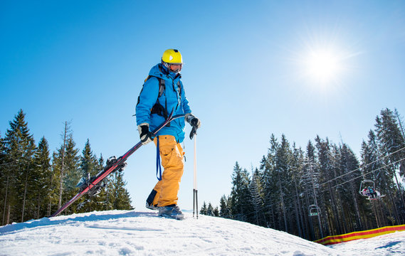 Skier walking in the mountains carrying his ski equipment copyspace nature active lifestyle resort leisure concept