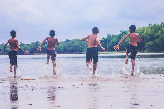 Group of asian young boys takeoff running for jump into the lake.