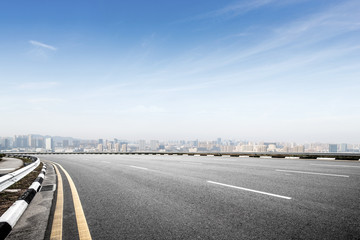 Fototapeta premium empty asphalt road with modern cityscape in foggy day