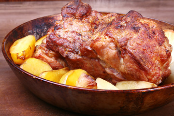 Juicy pork neck chops are grilled with potatoes on a stone Background.