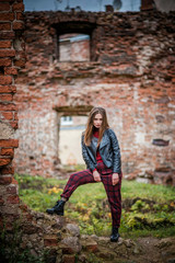 Fototapeta na wymiar Cool girl in black leather jacket against a brick wall