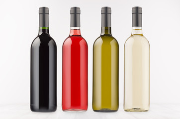  Wine bottles collection different colors on white wooden board, mock up. Template for advertising, design, branding identity.