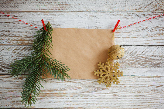 Christmas decorations hanging on cord on white wooden background.