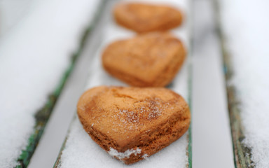 Homemade cookies with sugar and cinnamon in the form of hearts on a background of snow