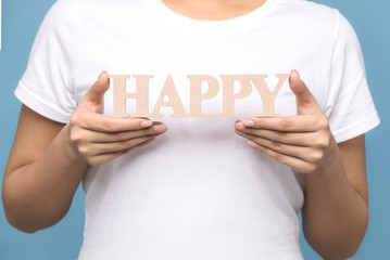 Young woman holding HAPPY sign.