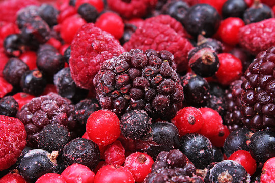 Frozen mixed berries as background. Blueberries,raspberries black berries and currant mulberry texture pattern. Photo.