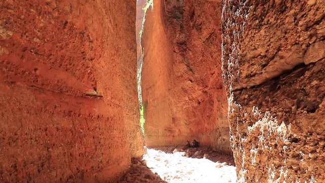 Vertical pan looking outwards towards the entrance of Echidna Chasm at midday capturing the brief moments when sunlight penetrates the chasm, Bungle Bungles, Purnululu World Heritage Listed Park.