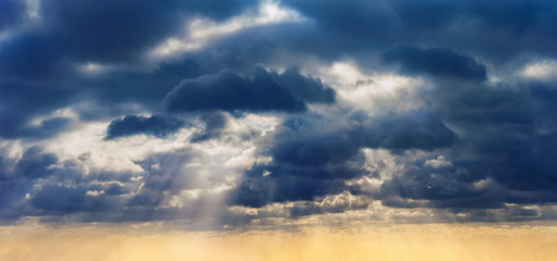 background panorama. rays of the sun make their way through dramatic clouds