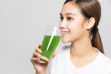 Young woman drinking a glass of vegetable juice.