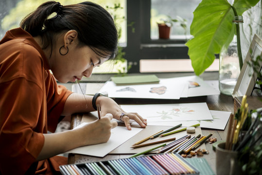 Asian woman is working on her hand drawing artwork
