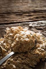Dry rolled oat flakes oatmeal on old wooden