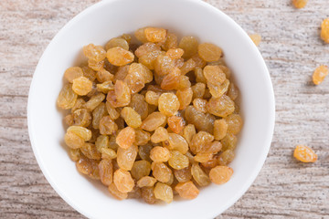 Dried yellow raisin fruits on  wood background