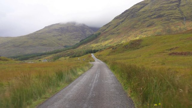 Driving on a road in Wild Glen Etive Valley in Scotland