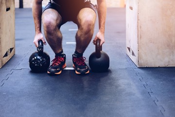 Man pulling kettlebells weights in the functional fitness gym