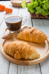 Tasty croissants on white wood background
