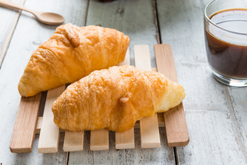 Tasty croissants on white wood background