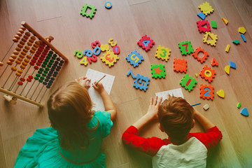 little boy and girl learn to write and calculate numbers