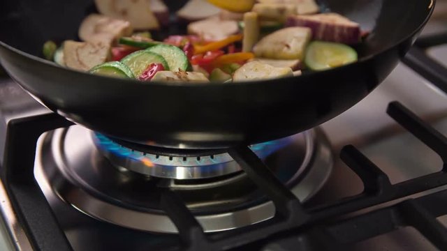 Stirring delicious colourful vegetables that are cooking in a wok. Cook will definitely surprise his demanding guests.