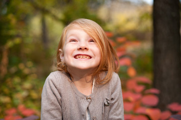 Red-haired girl in the autumn forest