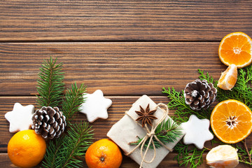 Christmas gift and tangerines on a wooden background. View from above