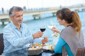 cheerful couple drinking wine and enjoying outdoors