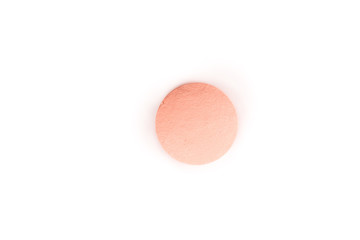 close-up of a salmon pink pill from above isolated on a white background.psd