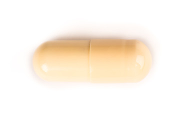 close-up of a yellow pill from above isolated on a white background.psd