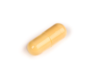 close-up of a yellow pill isolated on a white backgound.psd