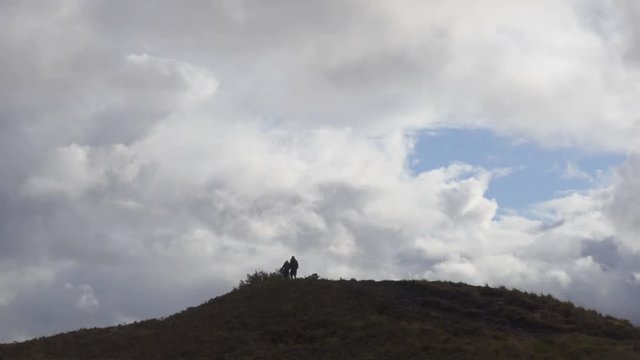 Silhouettes of Tourists on a Hill in the Scottish Highlands