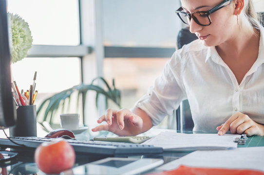 Office worker. Young businesswoman using calculator and laptop for calaulating finance, tax, accounting, statistics and analytic research concept.