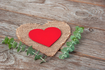 Decorative red wooden heart on on a burlap napkin in the shape of a heart a wooden background.Two Valentine hearts. Valentine's Day or Love concept.