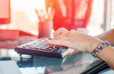 Fototapeta premium Working with computer in the office, woman typing on the keyboard. Female hands on the keyboard.