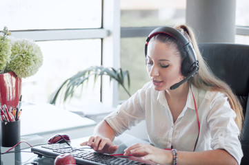 Female operator in the call center,  working in office.