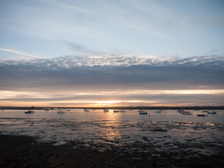 sun set sky dramatic clouds sea front beach harbor marina boats moored landscape