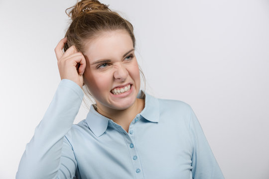 Junge Frau macht ein verwirrtes, nachdenkliches Gesicht