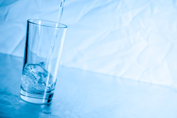 Glass of water in blue