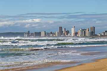 Rough sea against blue cloudy city skyline in  Durban