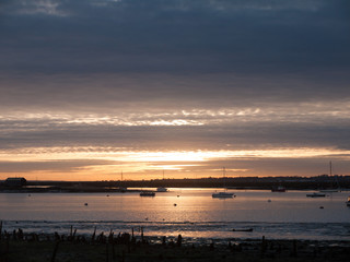 sun set sky dramatic clouds sea front beach harbor marina boats moored landscape