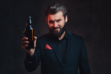 A man in a black suit presenting craft beer.