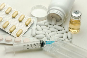 Pills, vitamins and syringe for injection with medications isolated on white background