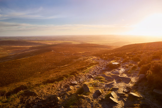 Red, Orange and yellow glow of a sunset over moors and hills in the English Countryside. Simonside Hills near Rothbury, England UK.