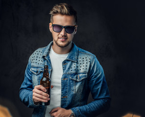 A man holds a bottle with craft beer.