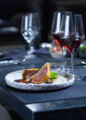 Grilled steak meat with potato gratin and glass of red wine