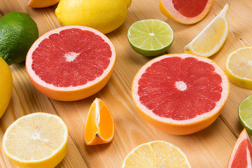 a set of sliced citrus fruits lie together on a wooden board