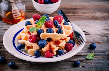 Fresh homemade belgian waffles with blueberries and raspberries for breakfast