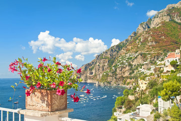 beautiful European town, sea and mountains with flowers at foreground