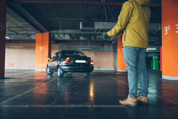 young woman parking car in underground parking with man help