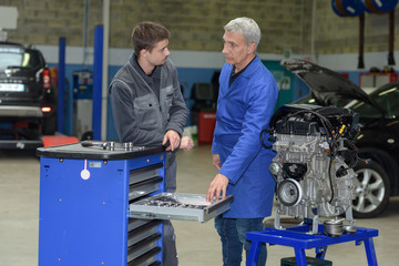 student with instructor repairing a car during apprenticeship