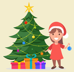 Fototapeta na wymiar Girl in Santa Claus hat standing near decorated Christmas tree with gift boxes under it